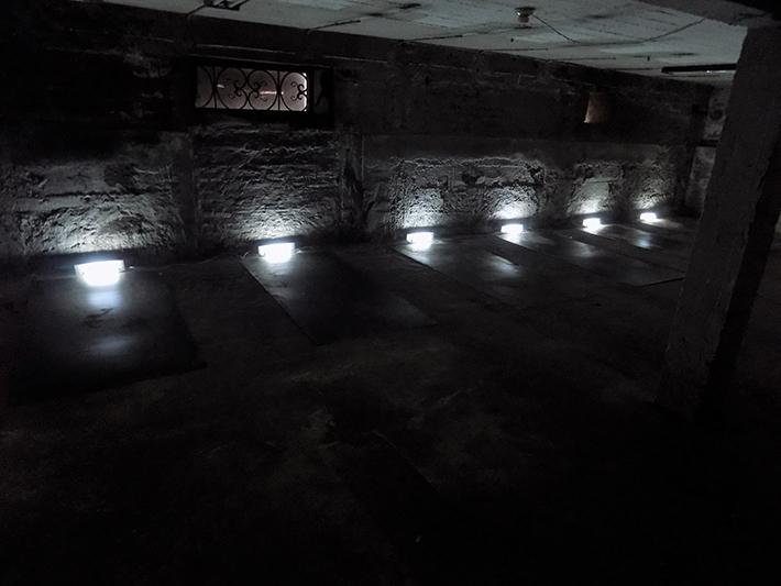 Esta instalación está compuesta por planchas grabadas en acero, luces fluorescentes y ampolletas, cajas de audio dispuestas en repeticiones y componen una exhibición deliberadamente oscura.